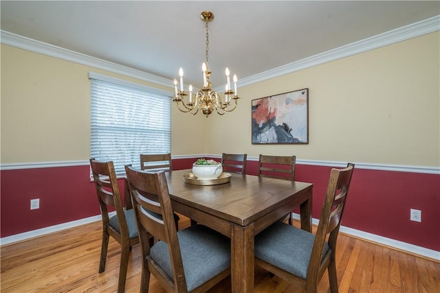 dining space with baseboards, light wood-type flooring, a notable chandelier, and crown molding