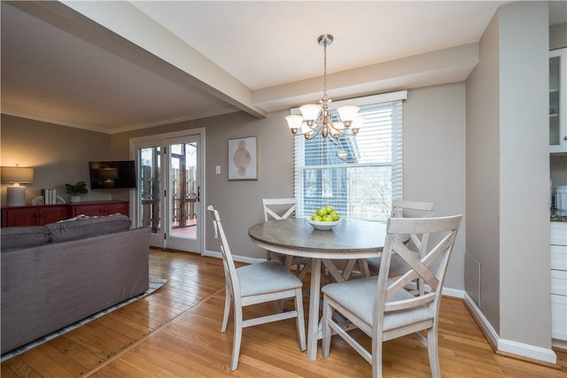 dining room featuring a notable chandelier, light wood-style flooring, and baseboards