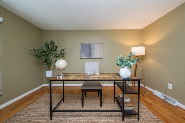 office area with baseboards and wood finished floors