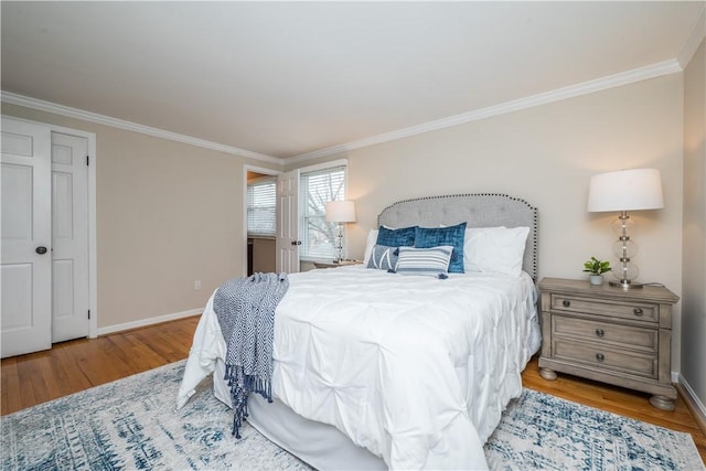 bedroom featuring baseboards, wood finished floors, and ornamental molding