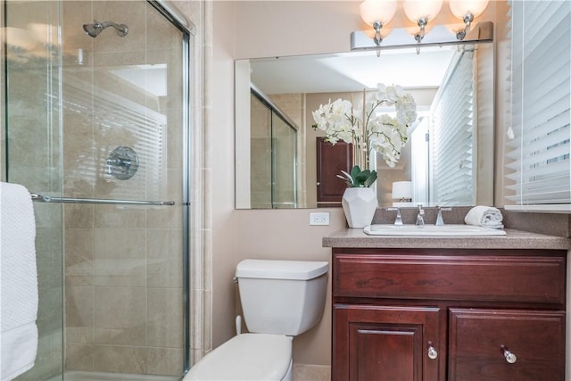 bathroom featuring a shower stall, toilet, and vanity