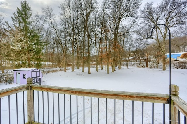 yard covered in snow featuring a shed