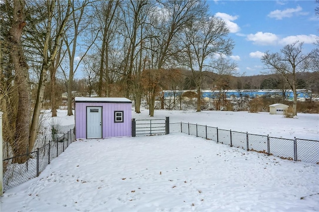 yard layered in snow featuring a storage shed