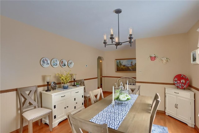 dining space with an inviting chandelier and light hardwood / wood-style flooring