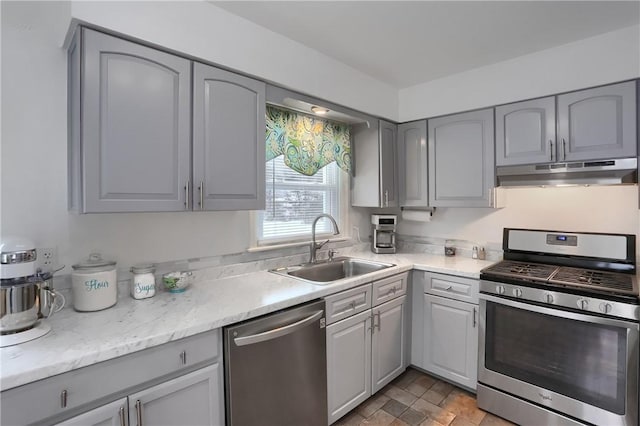 kitchen with appliances with stainless steel finishes, gray cabinets, and sink