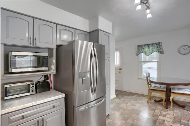 kitchen with appliances with stainless steel finishes and gray cabinets