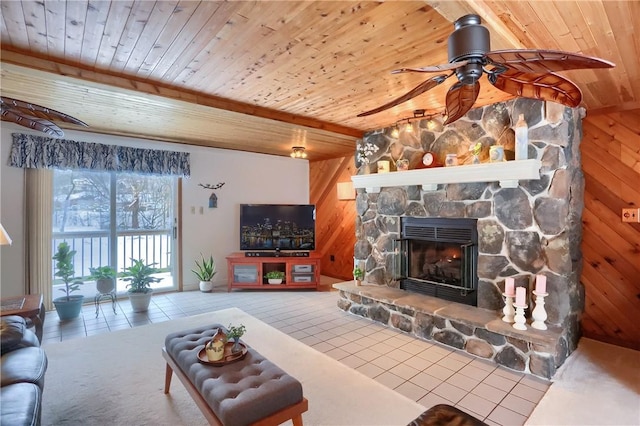 living room featuring wood ceiling, beamed ceiling, ceiling fan, wooden walls, and a fireplace