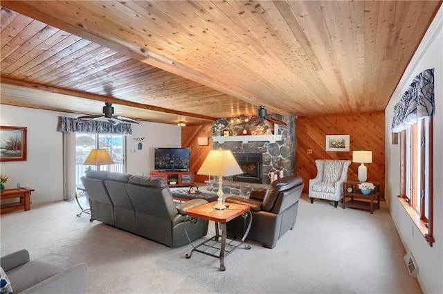 carpeted living room featuring wooden walls, a fireplace, ceiling fan, and wood ceiling