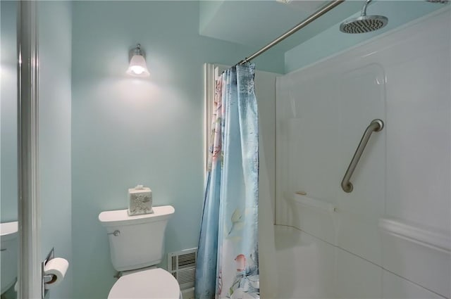 bathroom featuring toilet and a shower with curtain