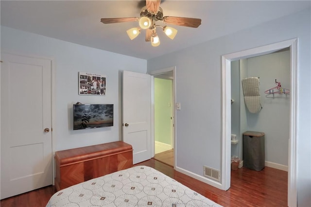 bedroom featuring ceiling fan, dark hardwood / wood-style flooring, and connected bathroom