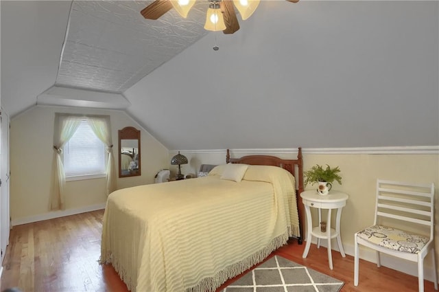 bedroom featuring vaulted ceiling, a textured ceiling, ceiling fan, and hardwood / wood-style flooring