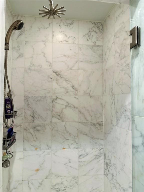 bathroom with a tile shower and ceiling fan