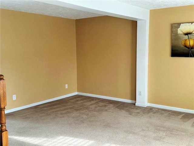 unfurnished room featuring a textured ceiling and carpet flooring