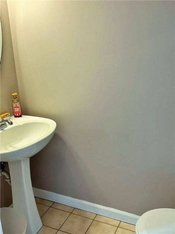 bathroom featuring toilet and tile patterned flooring