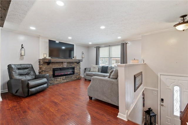 living room featuring a textured ceiling, dark hardwood / wood-style floors, crown molding, and a fireplace