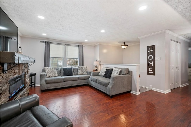 living room featuring a textured ceiling, dark hardwood / wood-style floors, ornamental molding, and a stone fireplace