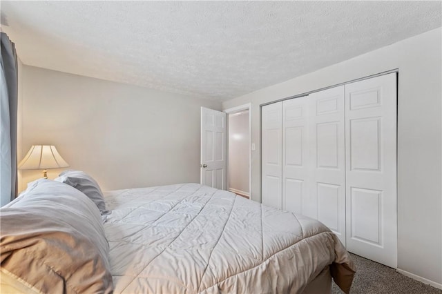 carpeted bedroom featuring a textured ceiling and a closet