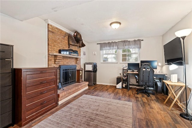 home office featuring a brick fireplace and dark hardwood / wood-style floors