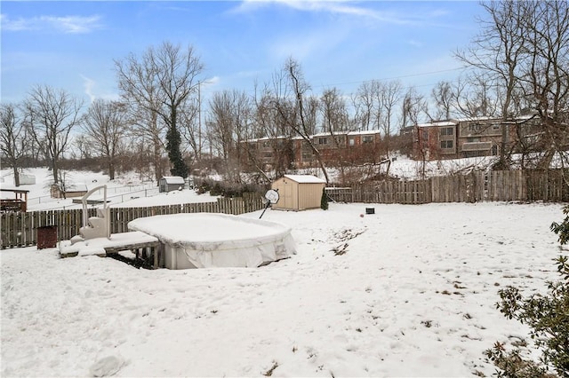 yard layered in snow featuring a storage unit