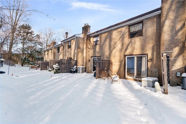 snow covered property with central AC