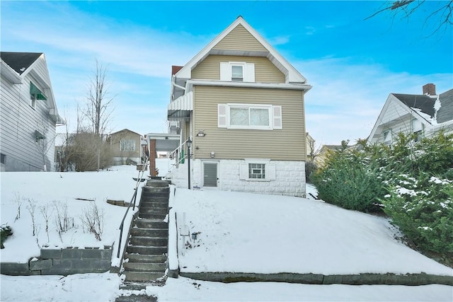 view of snow covered back of property