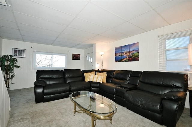 living room featuring a paneled ceiling and light carpet