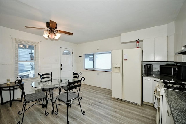 dining space with ceiling fan and light hardwood / wood-style flooring