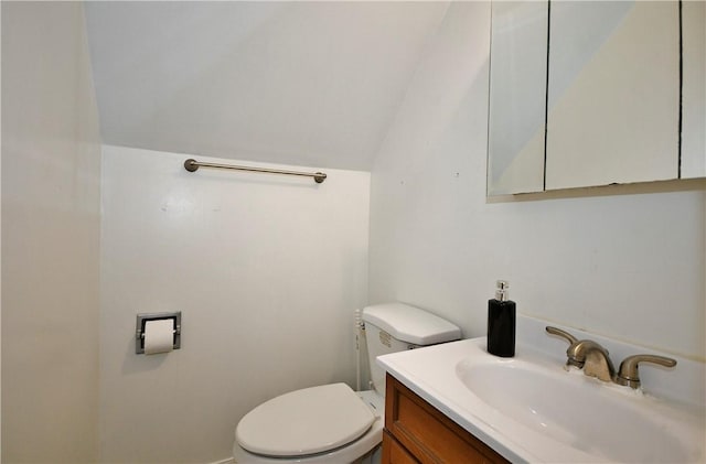 bathroom with toilet, vanity, and lofted ceiling