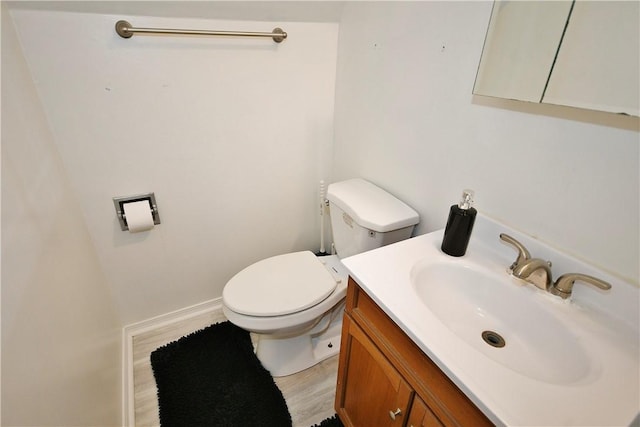 bathroom with hardwood / wood-style floors, vanity, and toilet