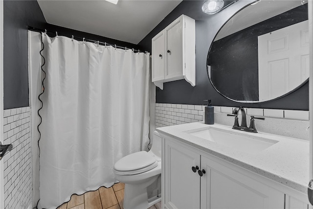 bathroom with tile walls, vanity, and toilet