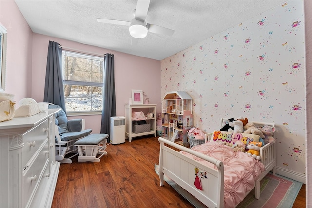 bedroom featuring a textured ceiling, ceiling fan, and wood-type flooring