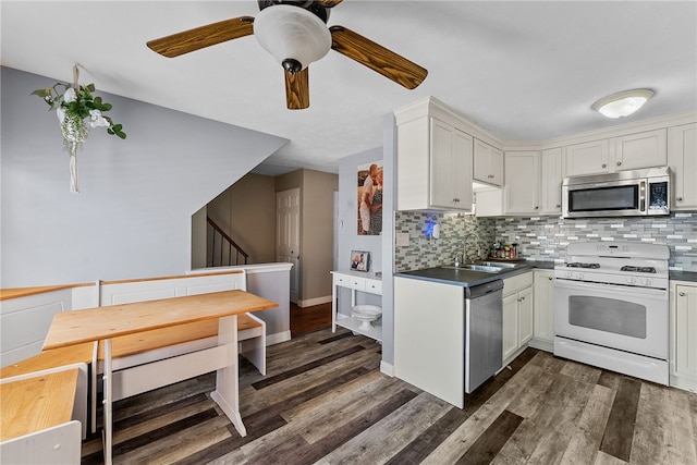 kitchen with appliances with stainless steel finishes, tasteful backsplash, white cabinets, and sink