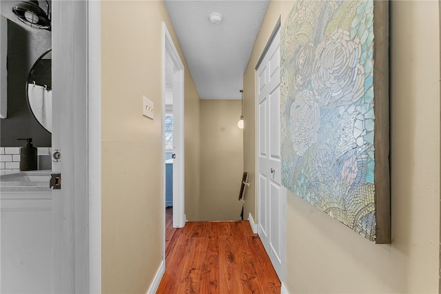 hallway featuring sink and wood-type flooring