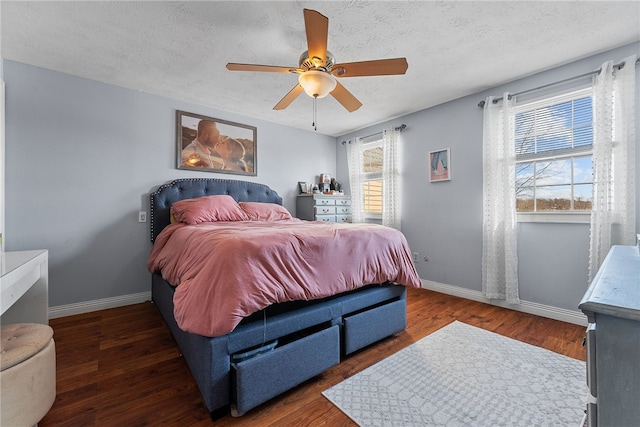 bedroom with ceiling fan, a textured ceiling, and dark hardwood / wood-style floors