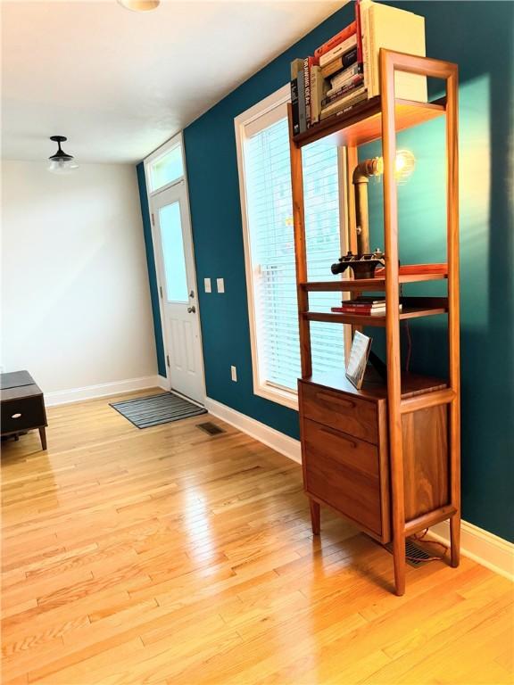 foyer entrance with light wood-type flooring and a healthy amount of sunlight