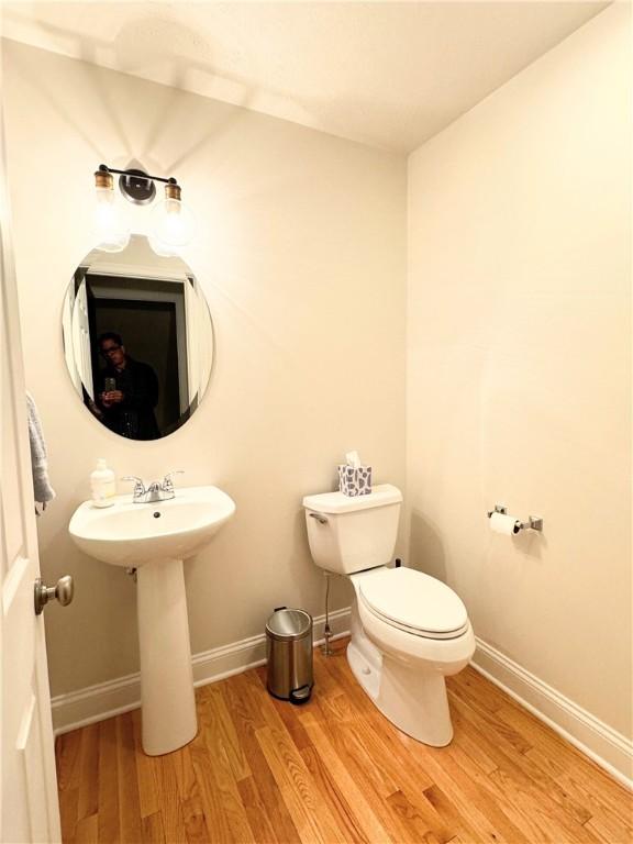 bathroom with toilet and wood-type flooring