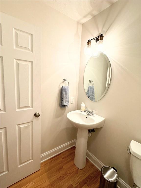 bathroom with toilet and wood-type flooring