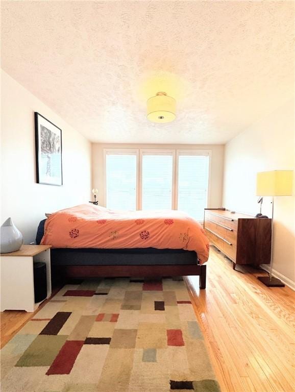 bedroom featuring a textured ceiling and light wood-type flooring