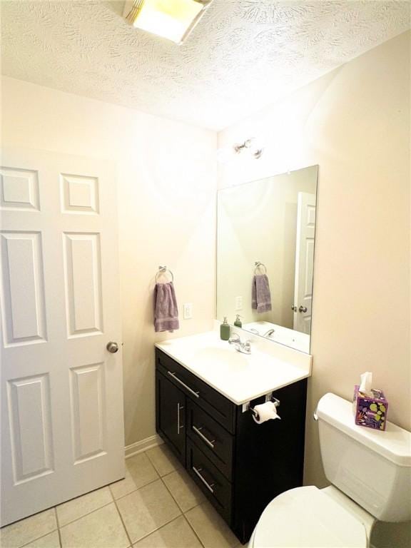 bathroom featuring vanity, a textured ceiling, tile patterned floors, and toilet