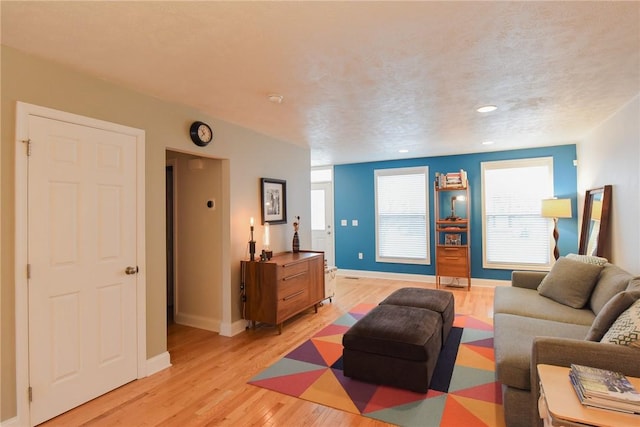 living room featuring a textured ceiling and light wood-type flooring