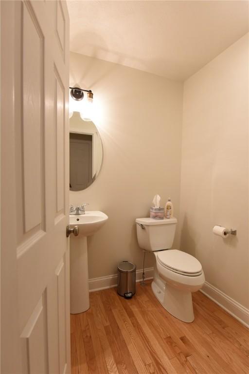 bathroom with wood-type flooring, sink, and toilet