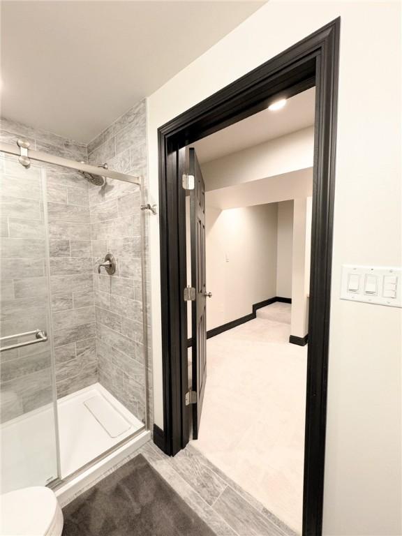 bathroom featuring an enclosed shower and toilet