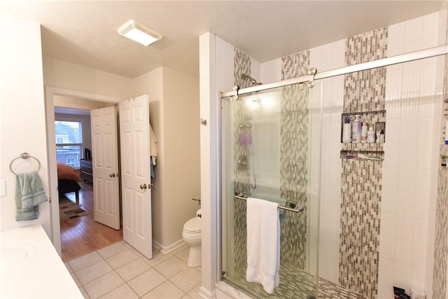 bathroom with tile patterned floors, toilet, and walk in shower