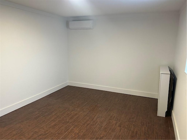 empty room featuring dark hardwood / wood-style flooring and a wall mounted air conditioner