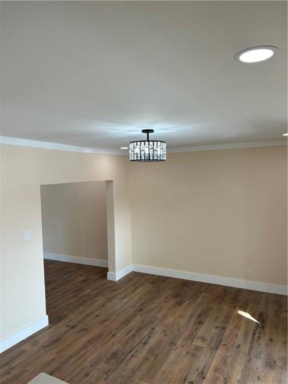 empty room featuring ornamental molding and dark hardwood / wood-style flooring