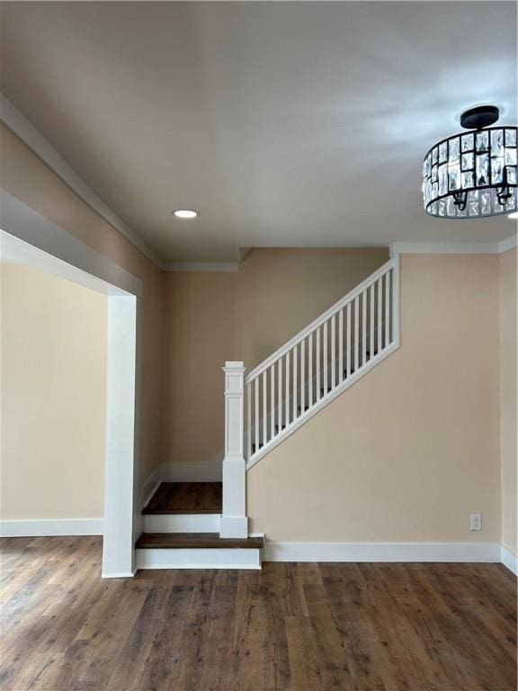 stairway with crown molding and hardwood / wood-style floors