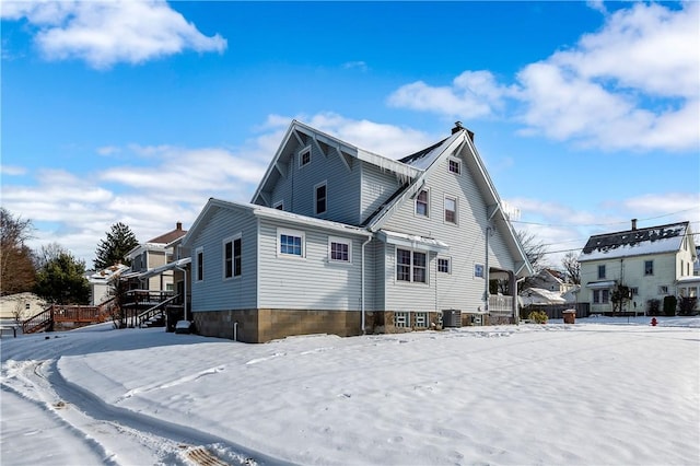 snow covered property with central air condition unit