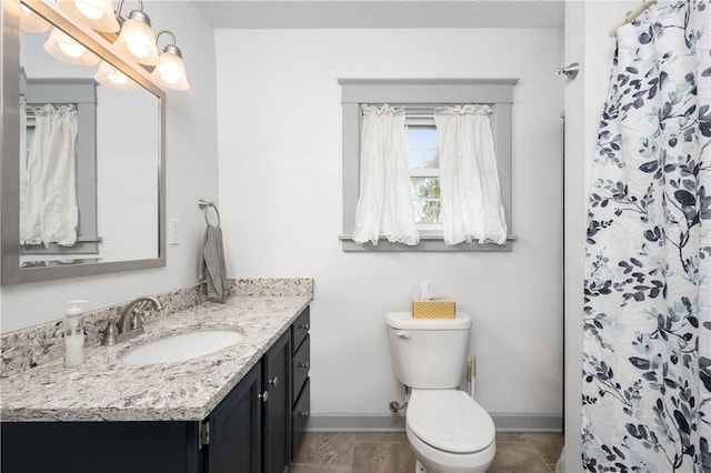 bathroom featuring toilet, vanity, and a shower with curtain