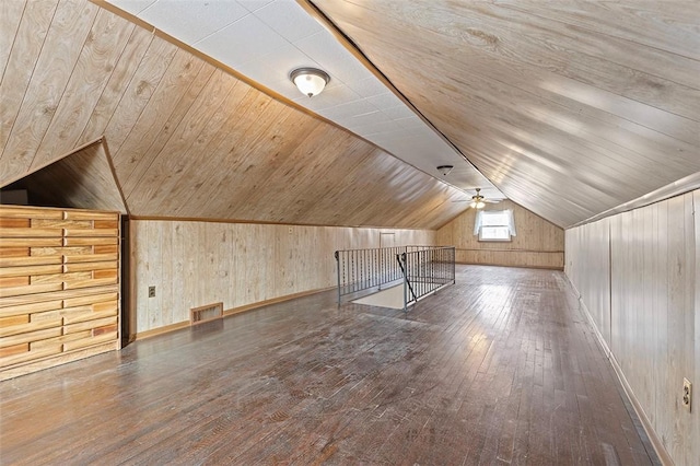 additional living space with hardwood / wood-style floors, wooden ceiling, vaulted ceiling, ceiling fan, and wooden walls