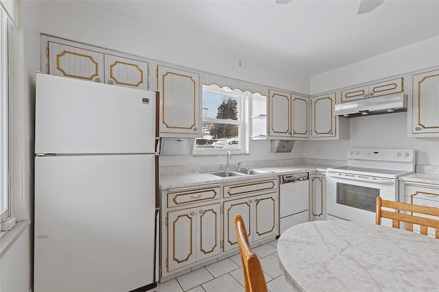 kitchen with white appliances, sink, and light tile patterned floors